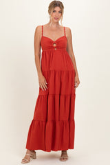 woman wearing a rust tiered maxi dress with a front cutout and spaghetti straps, styled with heeled sandals