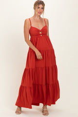 woman wearing a rust tiered maxi dress with a front cut-out and spaghetti straps