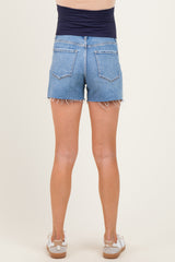 woman wearing a pair of light blue denim maternity shorts with frayed hem, showing her back view