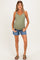 woman wearing a light olive green maternity tank top and denim shorts, showing her baby bump