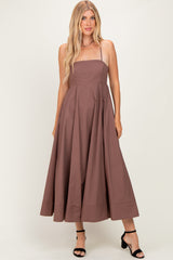 woman wearing a brown strapless maxi dress with a fitted bodice and full skirt