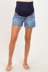 woman wearing navy blue maternity denim shorts with a distressed hem and a visible baby bump