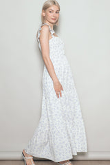 woman wearing a white floral maxi dress with ruffled straps and a tiered skirt