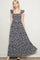 woman wearing a navy floral maxi dress with ruffled sleeves and button details
