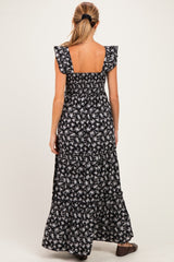 woman wearing a black floral maternity maxi dress with ruffled sleeves, showing the back view and relaxed fit