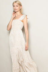 woman wearing a light beige floral maxi dress with ruffle straps and button details