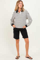 woman wearing a black and white striped maternity pullover with a collar and black maternity shorts
