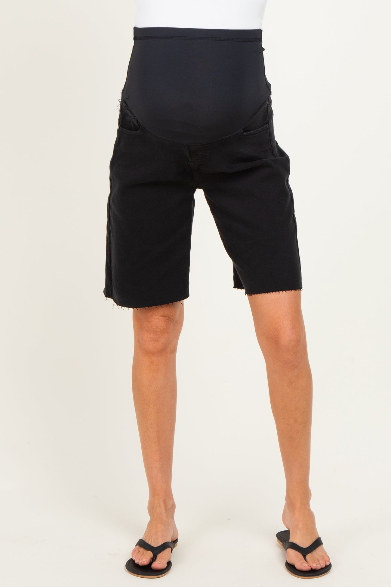 woman wearing black maternity denim shorts with a supportive belly panel and frayed hem