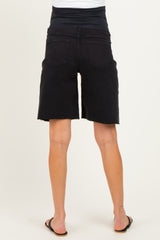 woman wearing black maternity denim shorts with a stretchy waistband, viewed from the back