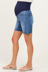 woman wearing maternity denim shorts with a dark blue belly panel and frayed hem, showing her baby bump