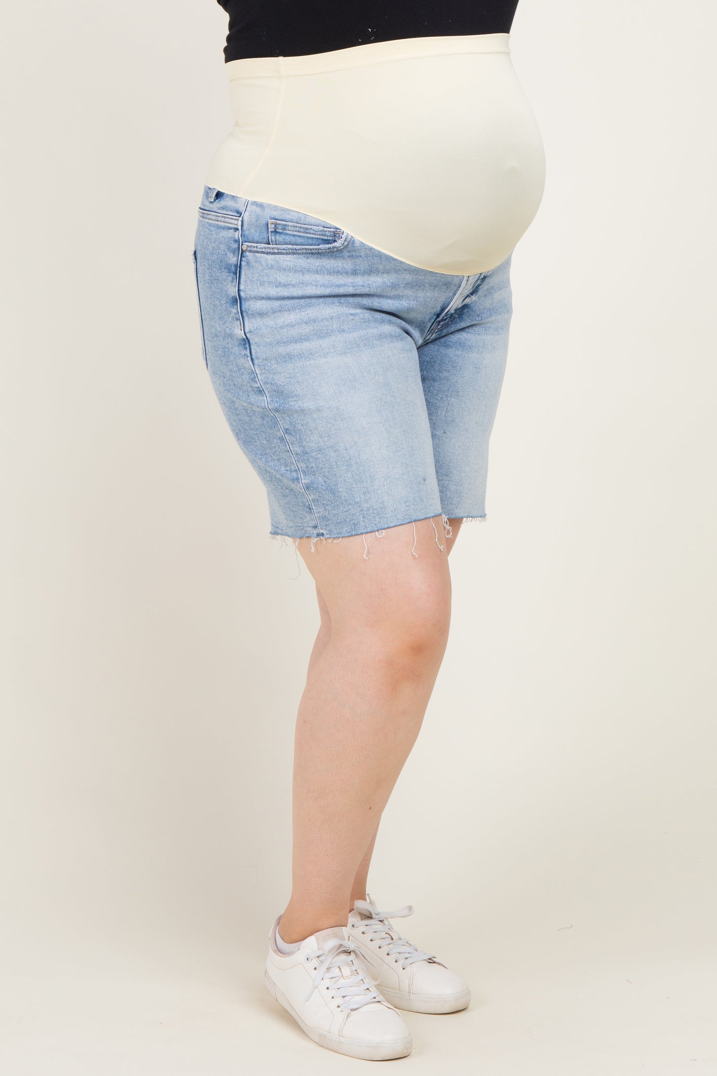 woman wearing light blue maternity plus denim shorts with a supportive belly band and a visible baby bump