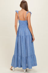 woman wearing a light blue tiered maternity maxi dress with ruffle straps and smocked back