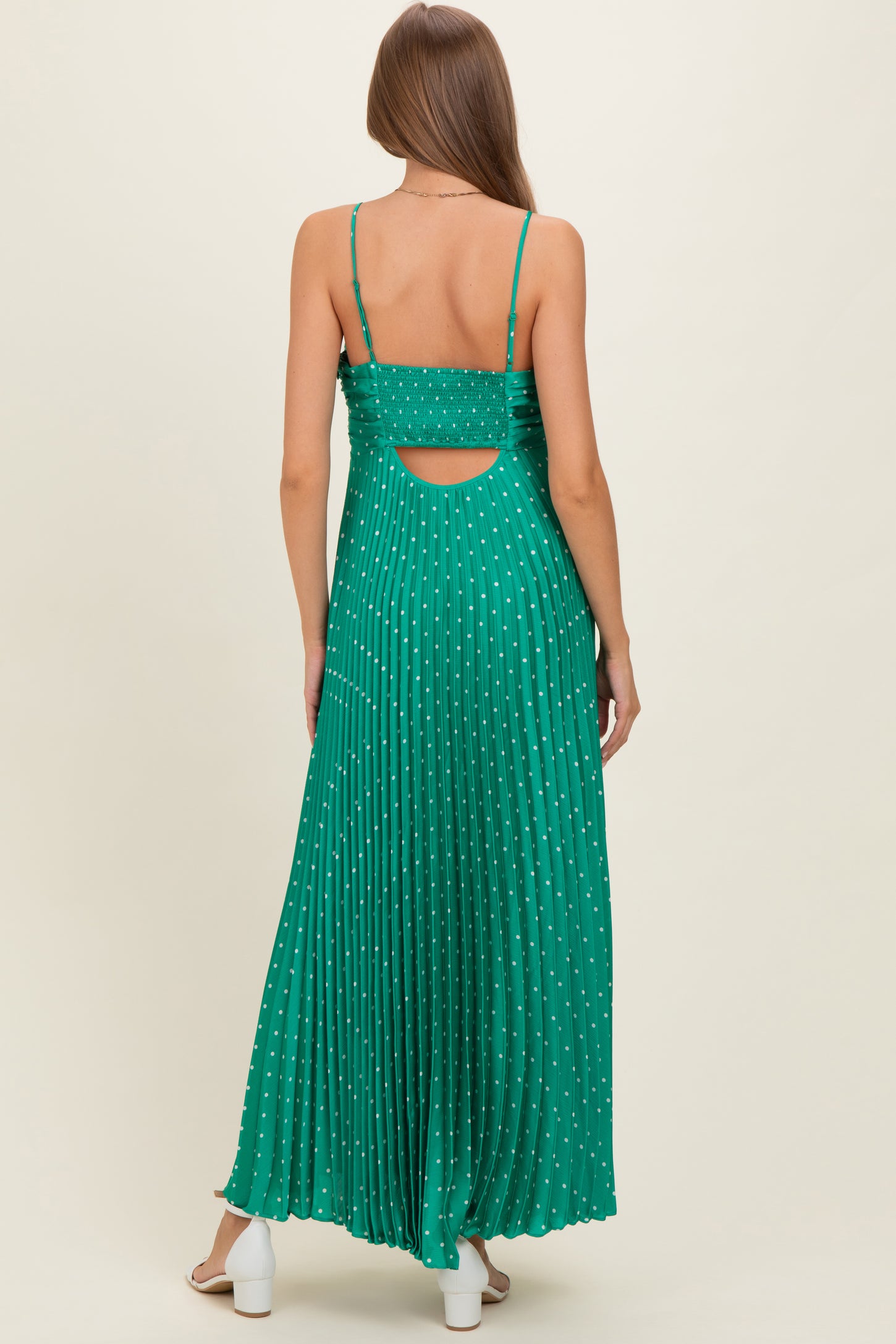 woman wearing a green maternity maxi dress with pleats and cut-out back detail