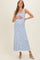woman wearing a striped maternity maxi dress with blue and white stripes, holding her baby bump