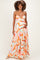 woman wearing a colorful pleated maternity maxi dress with a fitted bodice and adjustable straps, showcasing her baby bump