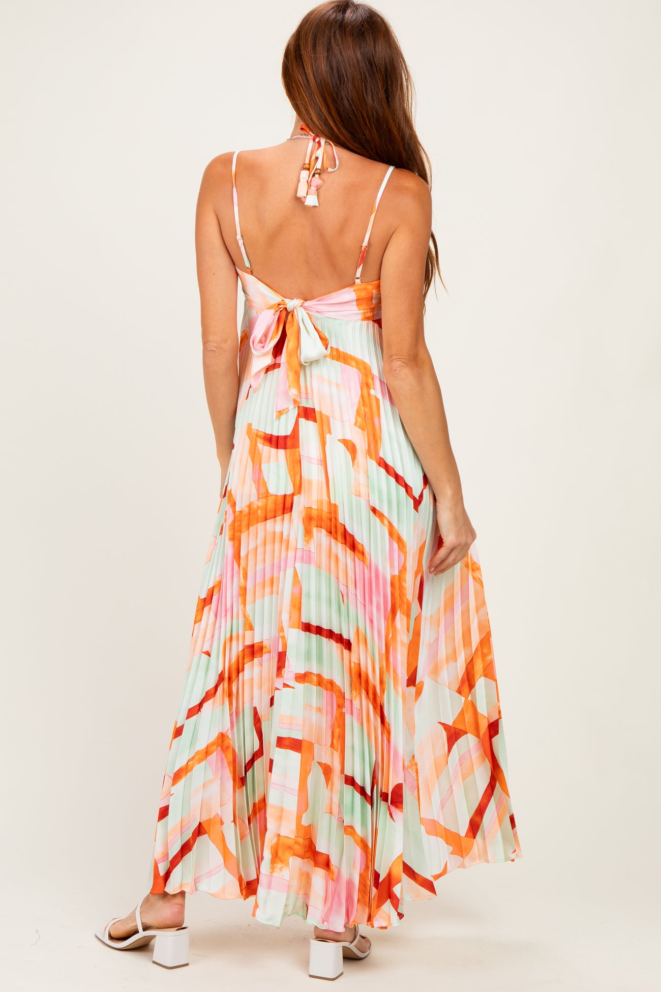 woman wearing a colorful maxi dress with a tie back and a flowing skirt
