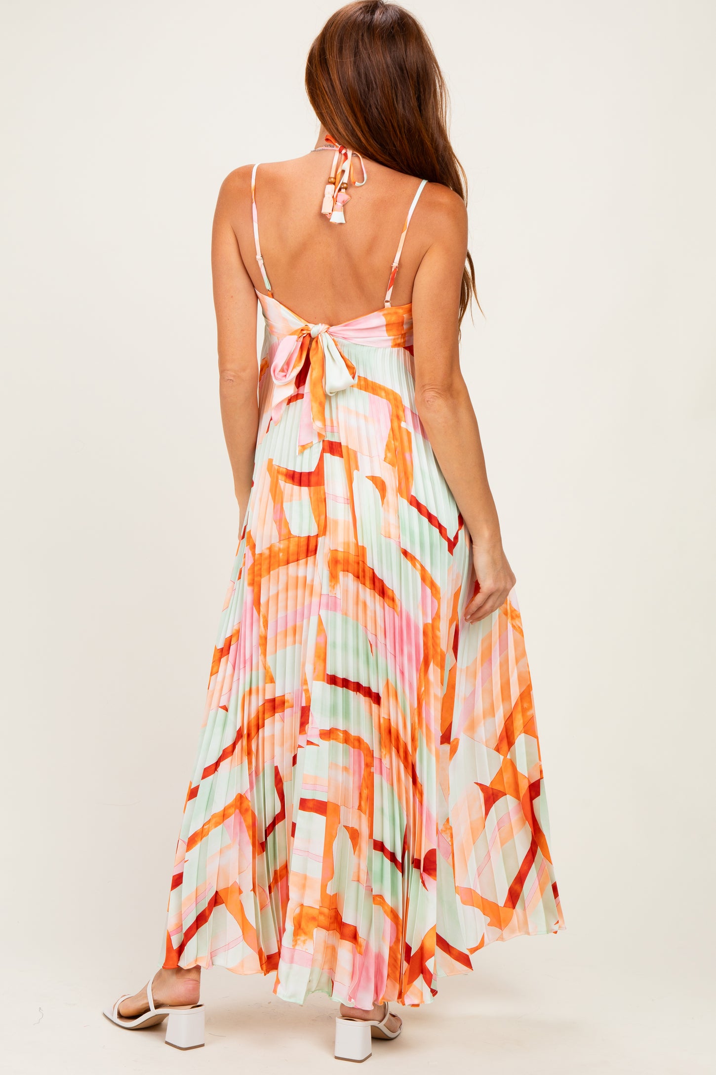 woman wearing a colorful maxi dress with a tie back and a flowing skirt