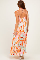 woman wearing a pastel colored maxi dress with a pleated design and tie-back detail