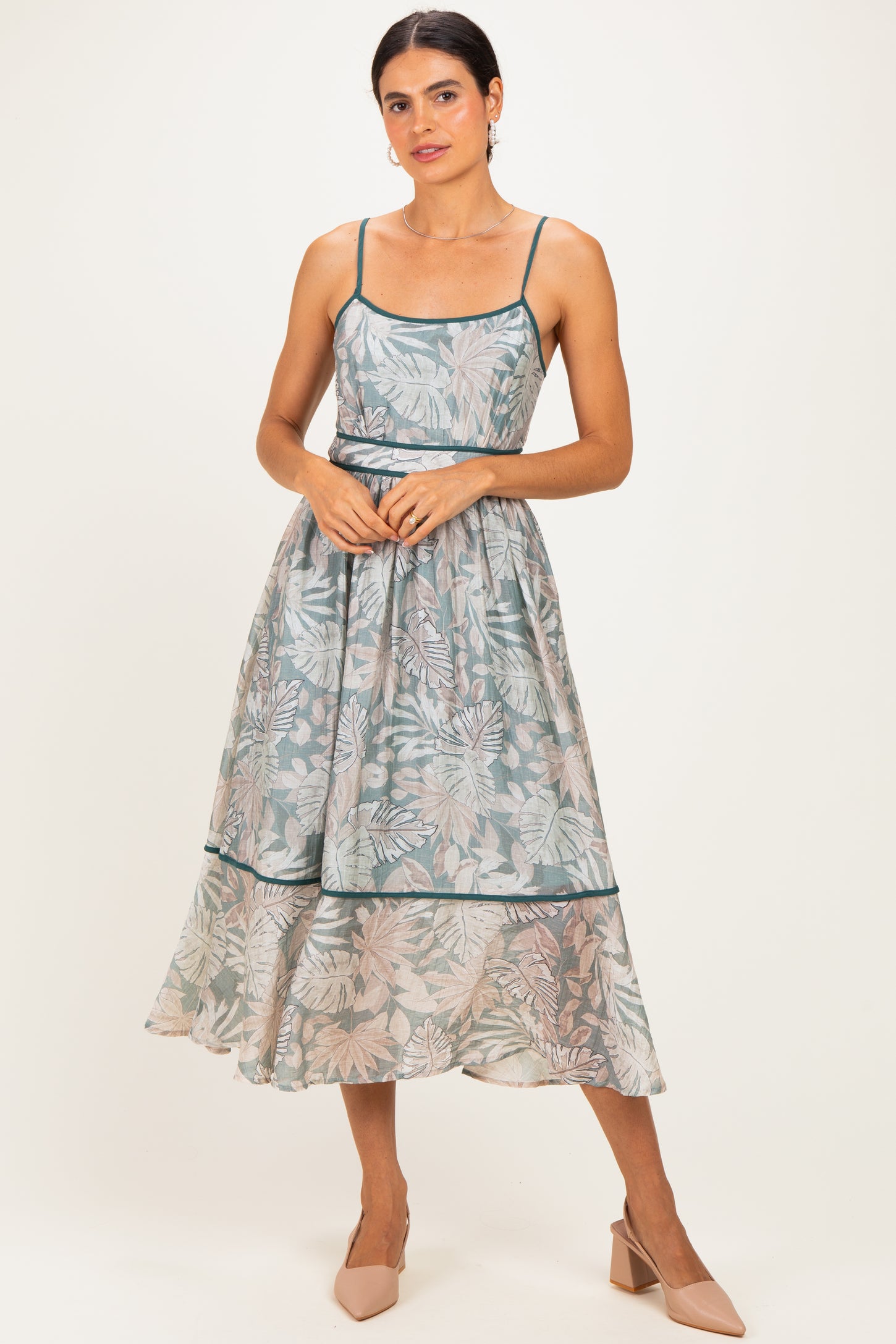 woman wearing a floral print midi dress with adjustable spaghetti straps and a flowing skirt, styled with nude heels