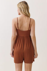 woman wearing a brown ribbed romper with spaghetti straps and a cinched waist, shown from the back