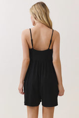 woman wearing a black sleeveless romper with a low back and loose fit