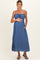 woman wearing a blue sleeveless maternity maxi dress with a tie front and pockets, showcasing her baby bump