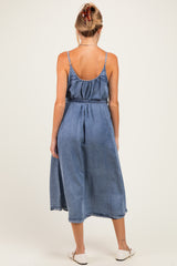 woman wearing a denim maternity dress with a flowy skirt and adjustable straps, showing a baby bump from the back