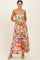 woman wearing a colorful floral maxi dress with adjustable straps and a flowy silhouette