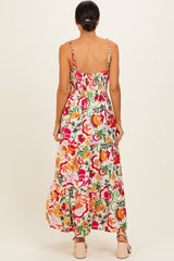 woman wearing a colorful floral maxi dress with adjustable straps and a smocked bodice, shown from the back