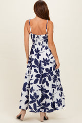 woman wearing a navy and white floral maxi dress with a smocked back and thin shoulder straps