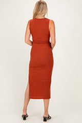woman wearing a rust-colored sleeveless maxi dress with a side slit, shown from the back