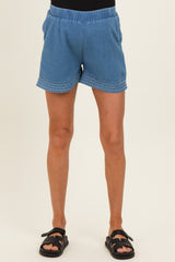 woman wearing blue maternity shorts with decorative stitching and an elastic waistband