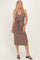 woman wearing a brown ribbed midi dress with a v-neck and tie belt, standing and smiling