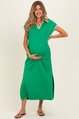woman wearing a green maternity dress with a v-neck and side slits, holding her baby bump
