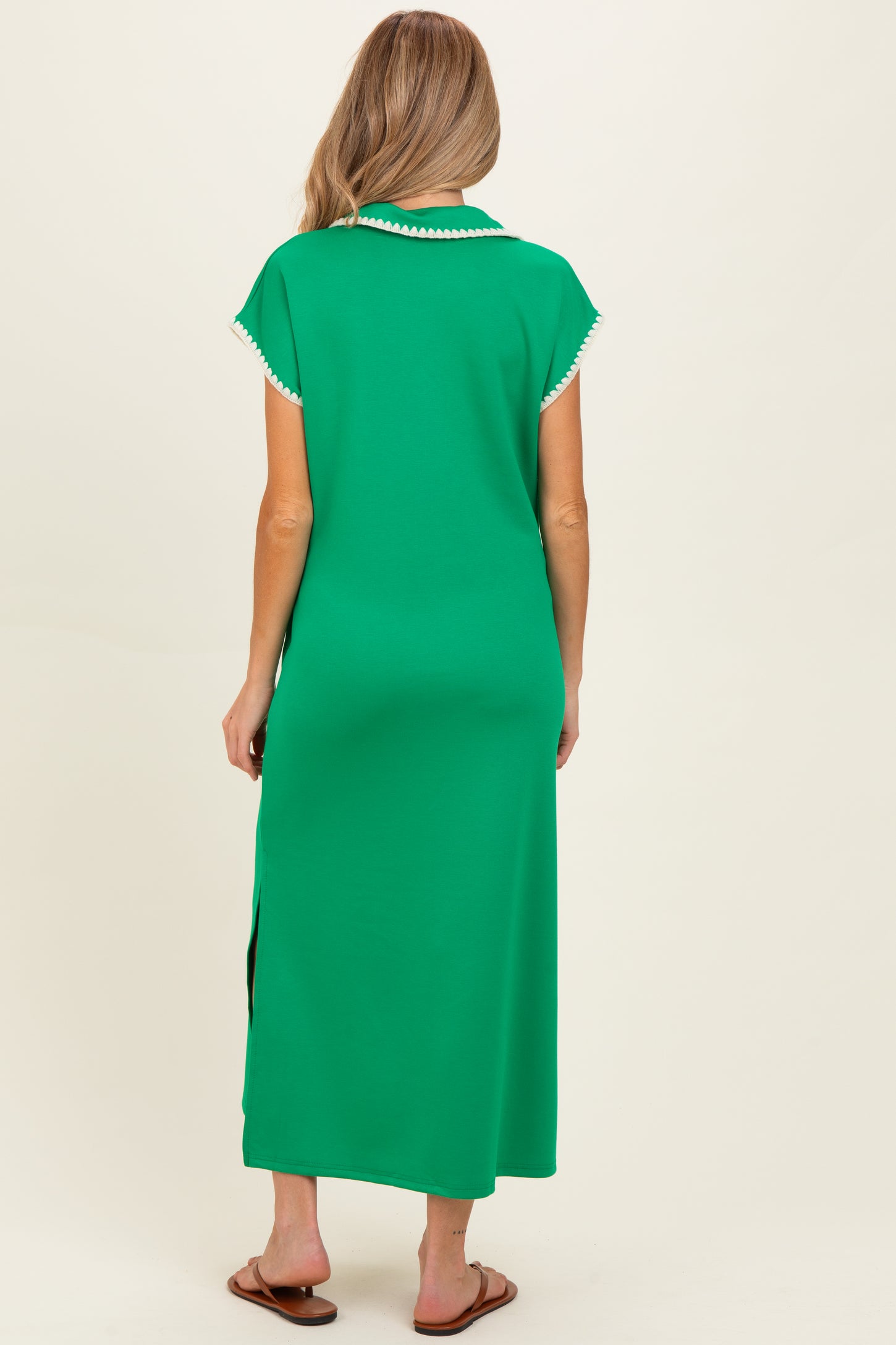 woman wearing a green maternity dress with short sleeves and side slits, shown from the back