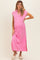 woman wearing a pink maternity dress with a collar and side slit, showcasing her baby bump