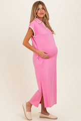 woman wearing a bright pink maternity dress with a collar and side slits, showing her baby bump
