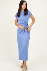 woman wearing a light blue short sleeve maxi dress with a tie detail at the waist
