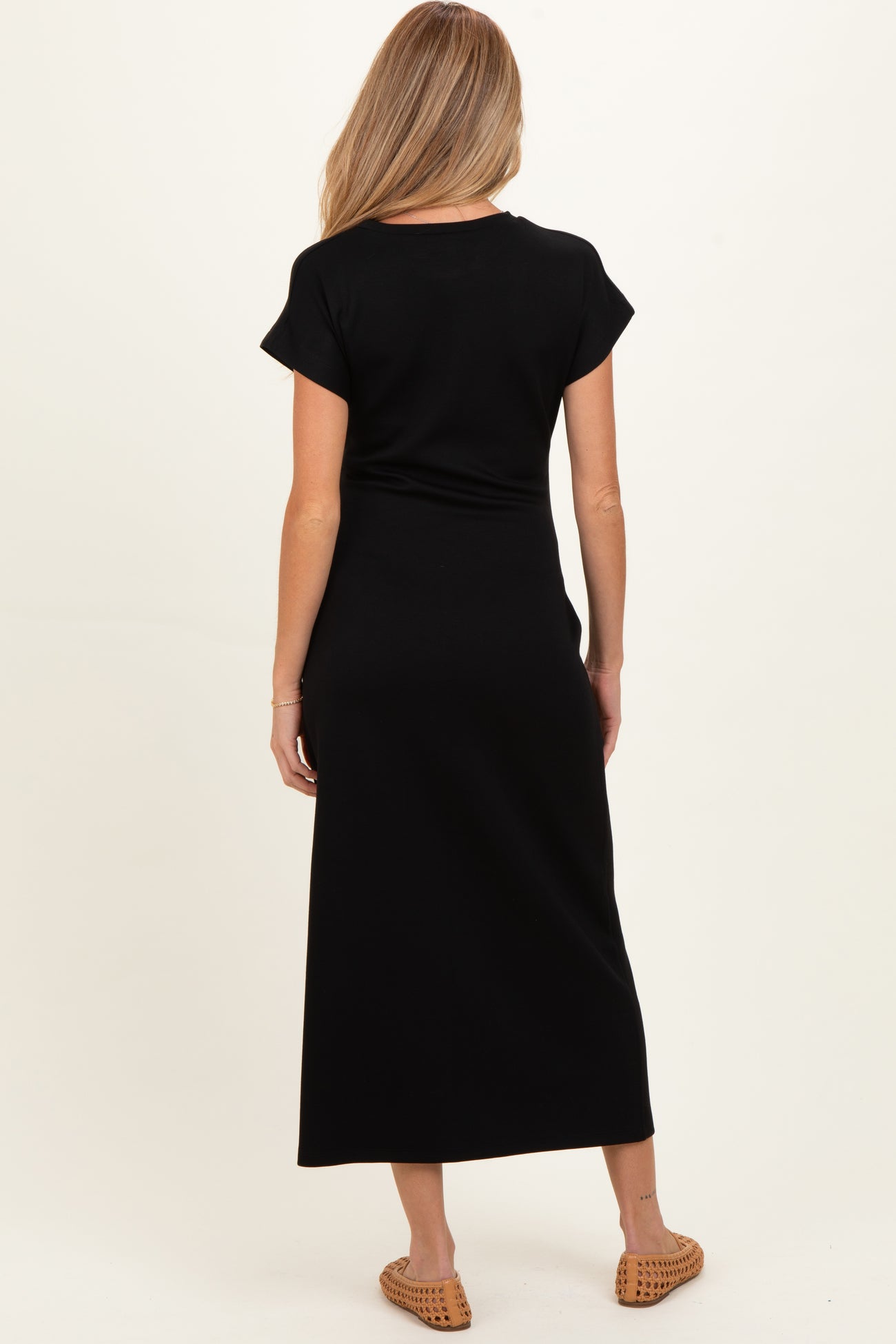 woman wearing a black short sleeve maternity maxi dress, view from the back
