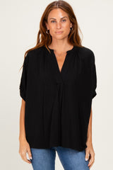 woman wearing a black loose-fit striped blouse with a v-neck and short sleeves, paired with blue jeans