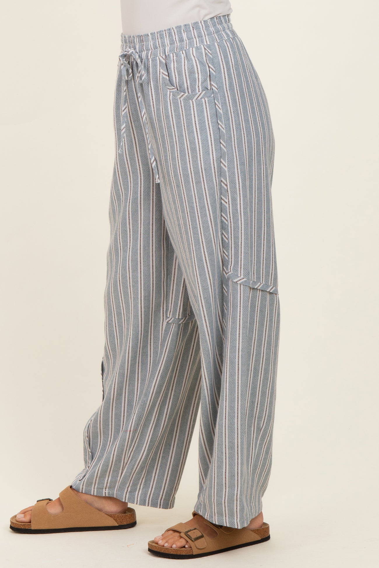 woman wearing light blue and white striped wide-leg pants with a drawstring waist and side pockets