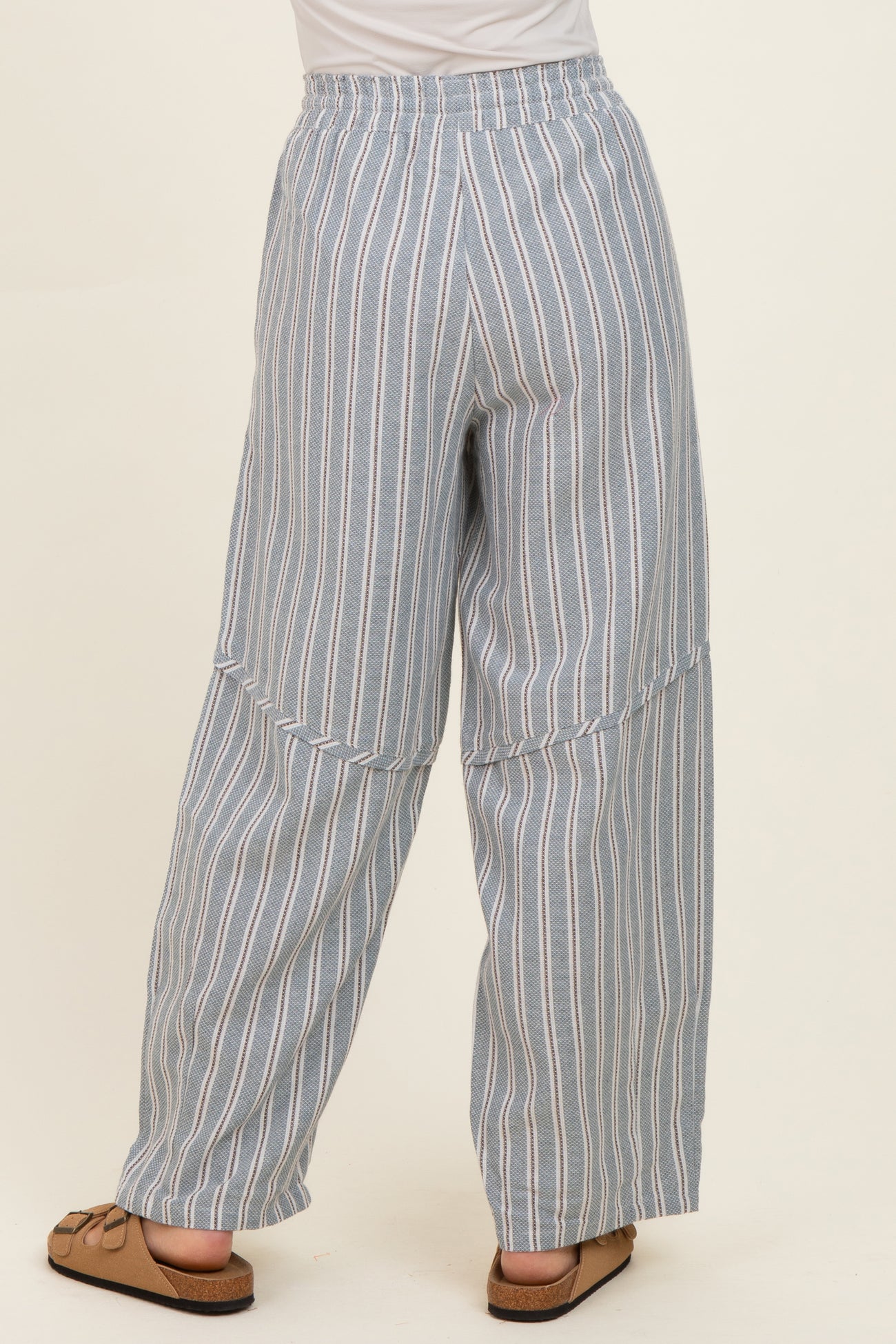 woman wearing light blue striped wide-leg pants with an elastic waistband, viewed from the back