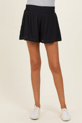 woman wearing black maternity shorts with an elastic waistband and a relaxed fit