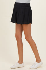 woman wearing black maternity shorts with an elastic waistband and a relaxed fit