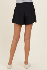 woman wearing black maternity shorts, view from the back, features an elastic waistband for comfort