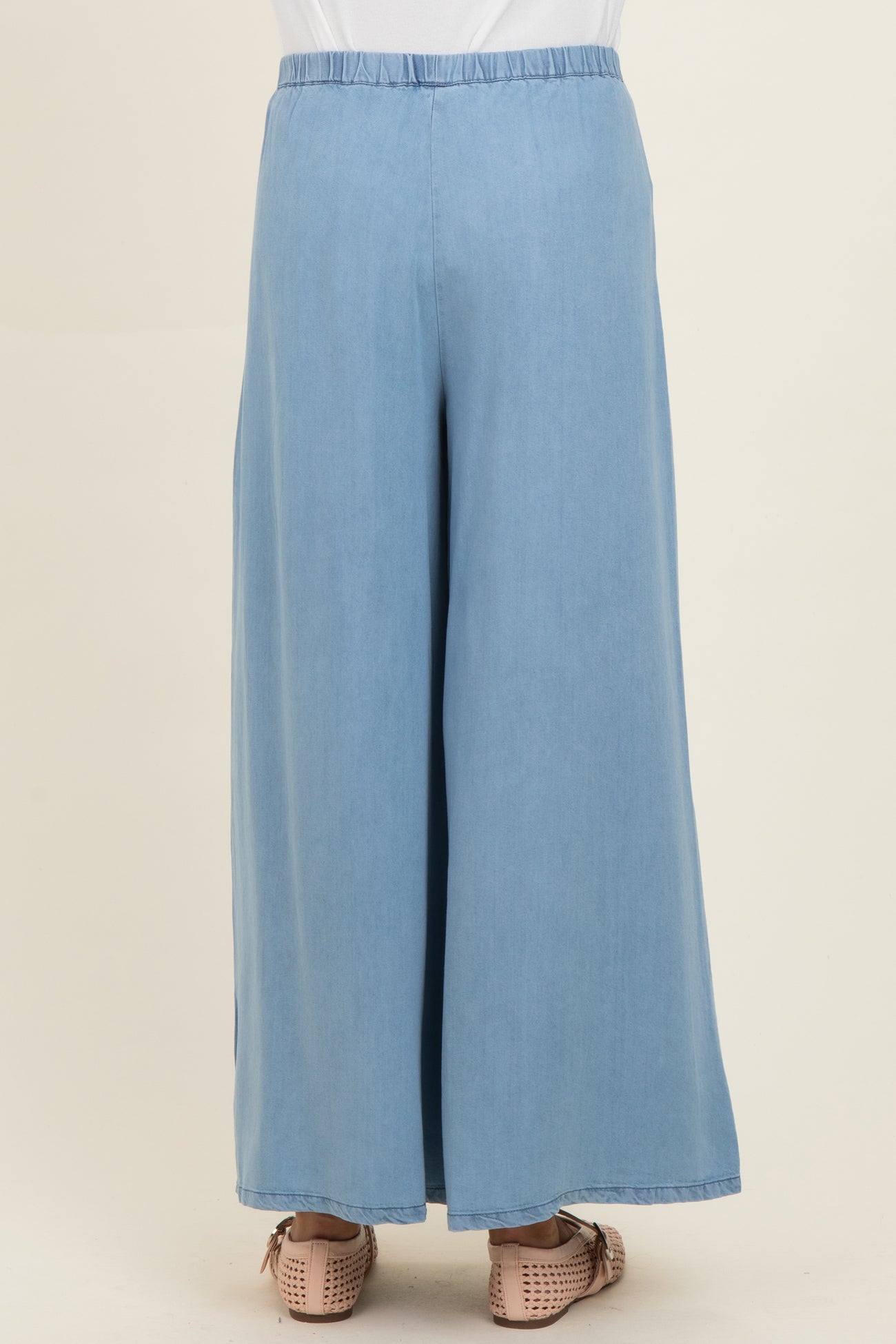 woman wearing light blue maternity wide-leg pants, shown from the back, with an elastic waistband and casual style
