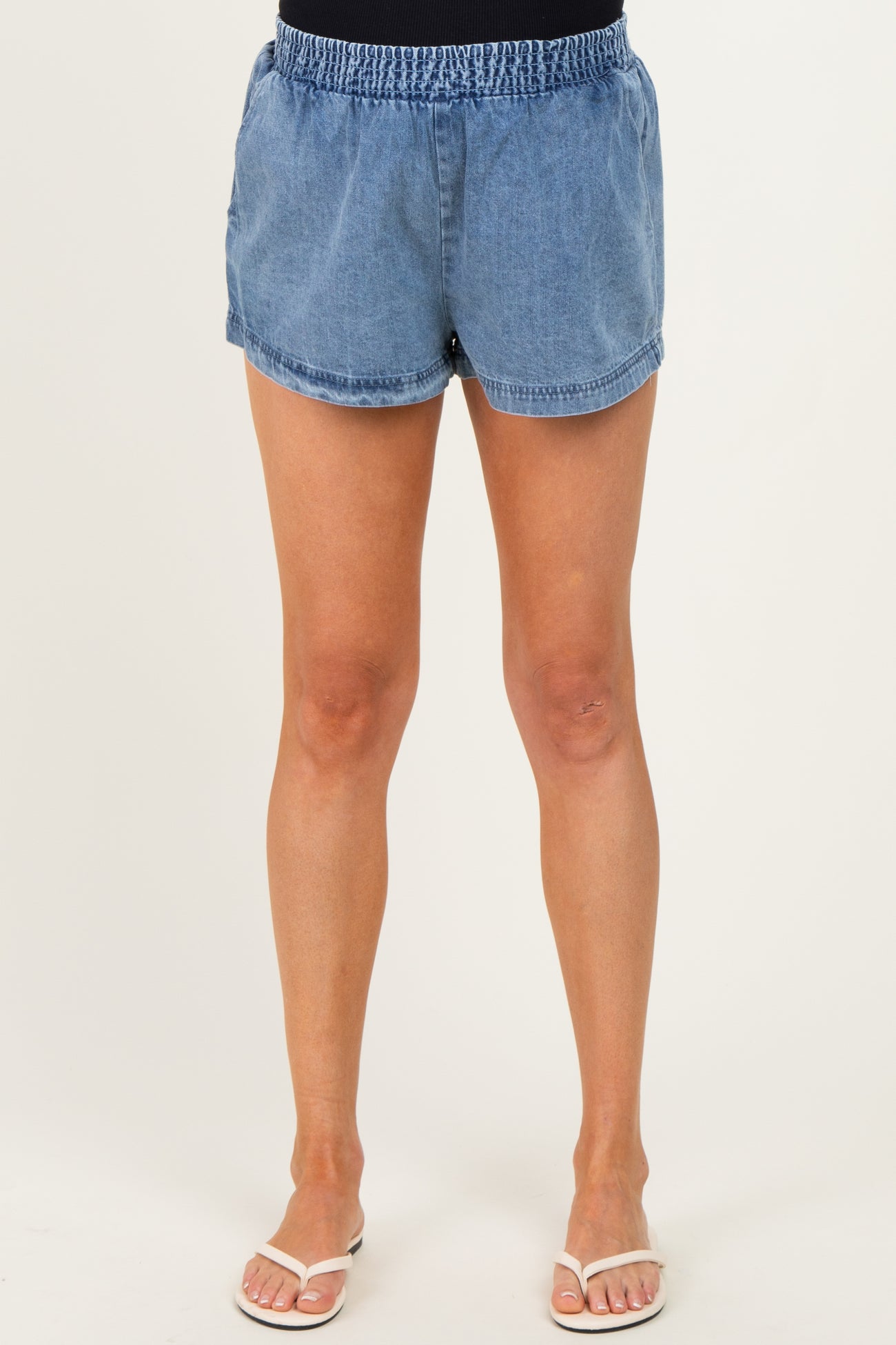 woman wearing denim blue maternity shorts with an elastic waistband