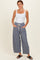 woman wearing a white fitted tank top and navy striped wide-leg pants with drawstring waist and side pockets