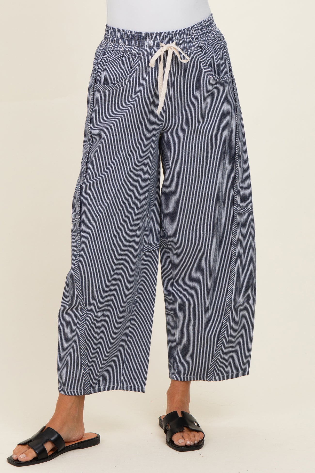 woman wearing navy striped wide-leg pants with an elastic waistband and drawstring, paired with black sandals