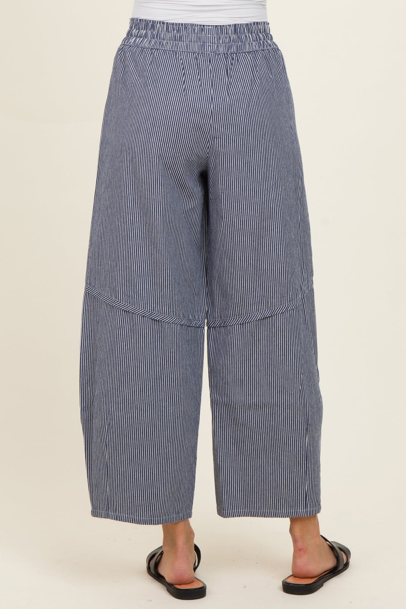 woman wearing navy blue striped wide-leg pants with an elastic waistband and a relaxed fit from the back